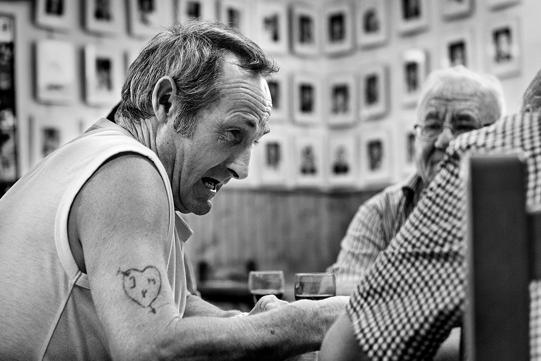 A man talking while seated in a bar.